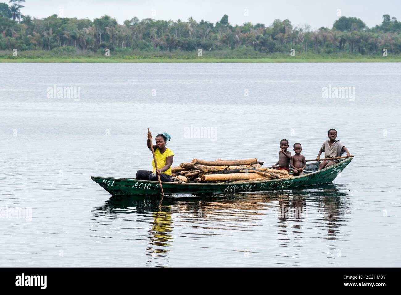 Trasporto in legno in barca sul lago Amansuri in Ghana, Africa Foto Stock