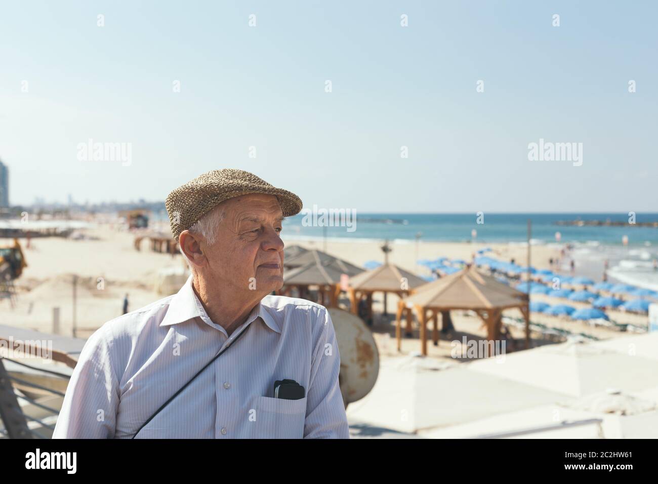 Primo piano ritratto di un uomo anziano in una cappelletta piatta su una spiaggia a Tel Aviv, Israele Foto Stock