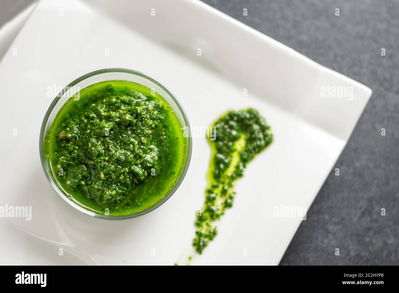 Salsa di pesto di basilico fresco fatto in casa in un vaso di vetro. Originario dell'italia, il pesto è comunemente fatto con basilico e utilizzato come salsa per la pasta. Foto Stock