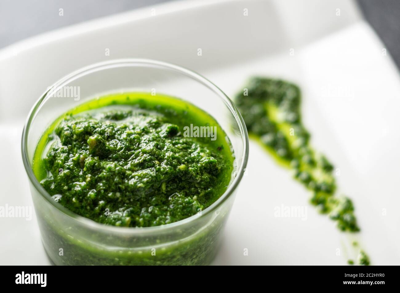 Salsa di pesto di basilico fresco fatto in casa in un vaso di vetro. Originario dell'italia, il pesto è comunemente fatto con basilico e utilizzato come salsa per la pasta. Foto Stock