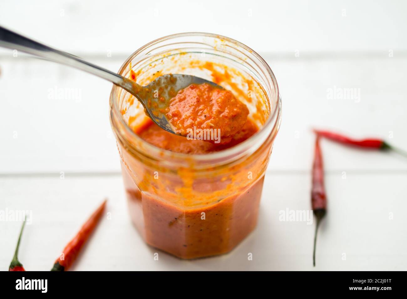 La salsa di Piri Piri è un tipo di salsa di peperoncino piccante usata come condimento o marinata tradizionalmente nella cucina portoghese. Visto qui in un vaso di vetro. Foto Stock