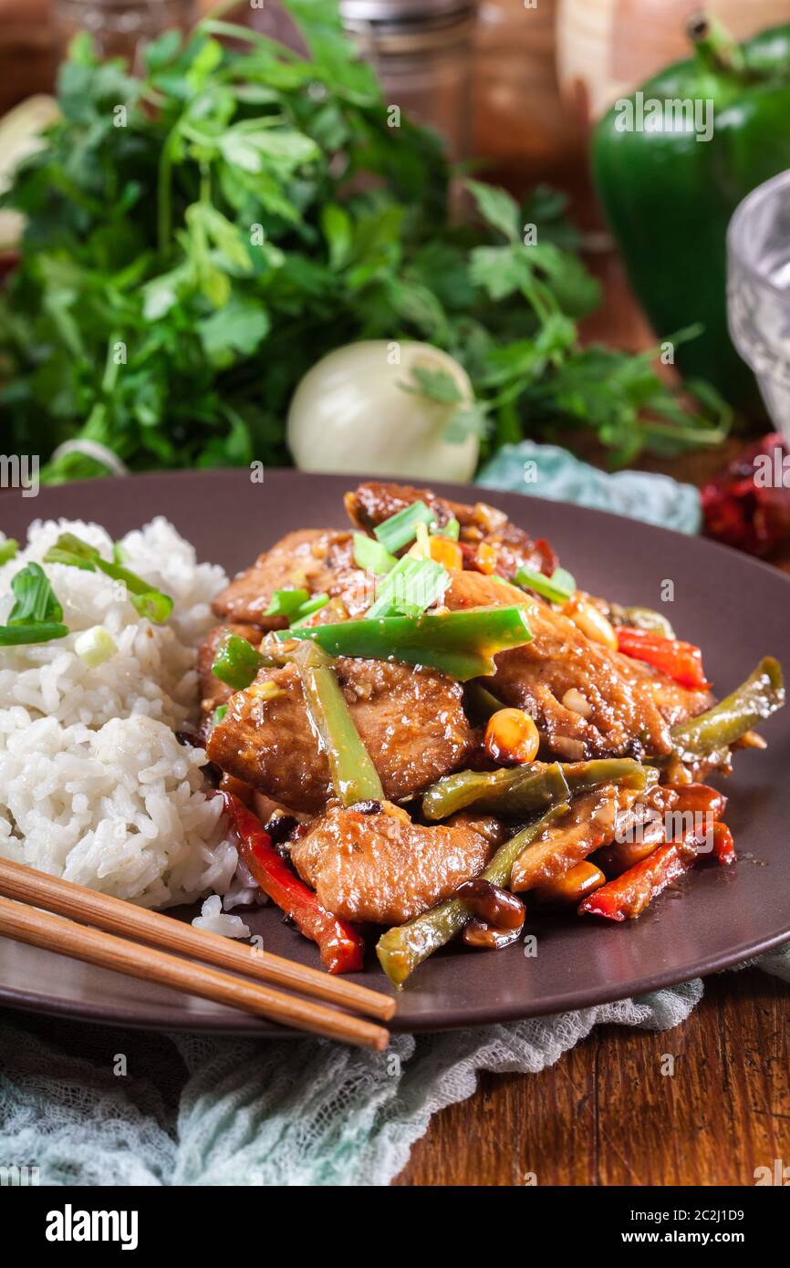 Pollo Kung Pao con peperoni e verdure servite con riso. Piatto tradizionale sichuan Foto Stock
