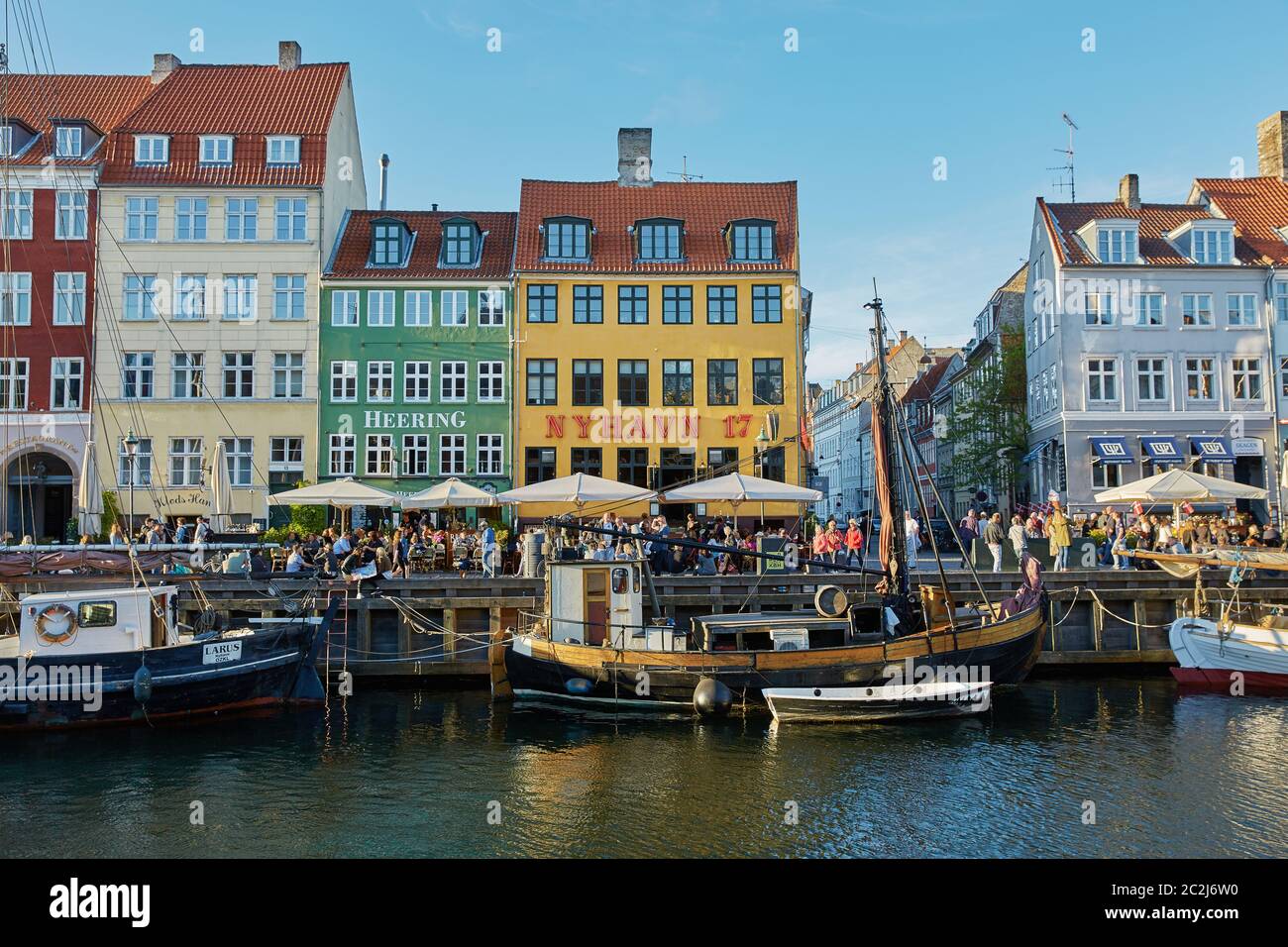 Facciate colorate e ristoranti sull'argine di Nyhavn e vecchie navi lungo il canale di Nyhavn Foto Stock