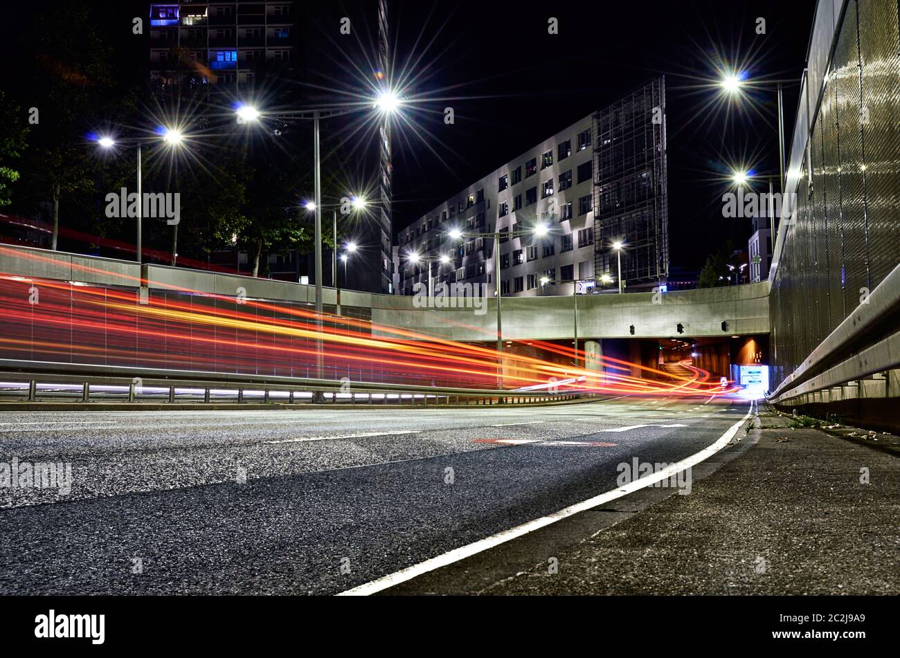 Tunnel aperto in città con sentieri per auto circondati da asfalto e cemento con edifici moderni Foto Stock