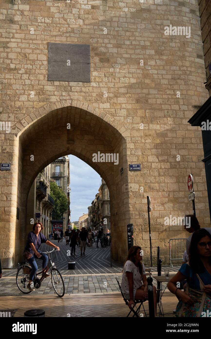 Ciclista che passa attraverso l'arco in pietra gotico del portale del campanile della Grosse Cloche, Bordeaux, Francia Foto Stock