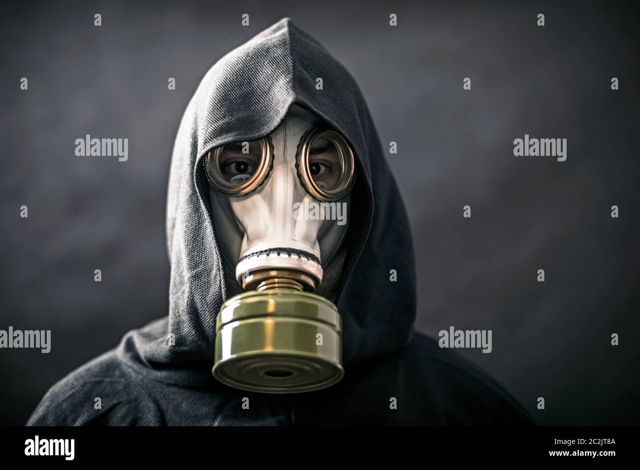 Uomo in una maschera a gas e con cappuccio mantello. Inquinamento dell ambiente. Foto Stock