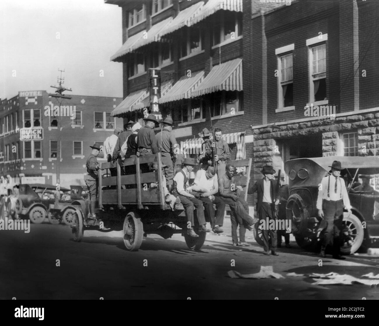 Camion sulla strada vicino all'Hotel Litan che trasporta i soldati e gli afroamericani durante le rivolte di corsa, Tulsa, Oklahoma, Stati Uniti, Alvin C. Krugnick Co., giugno 1921 Foto Stock