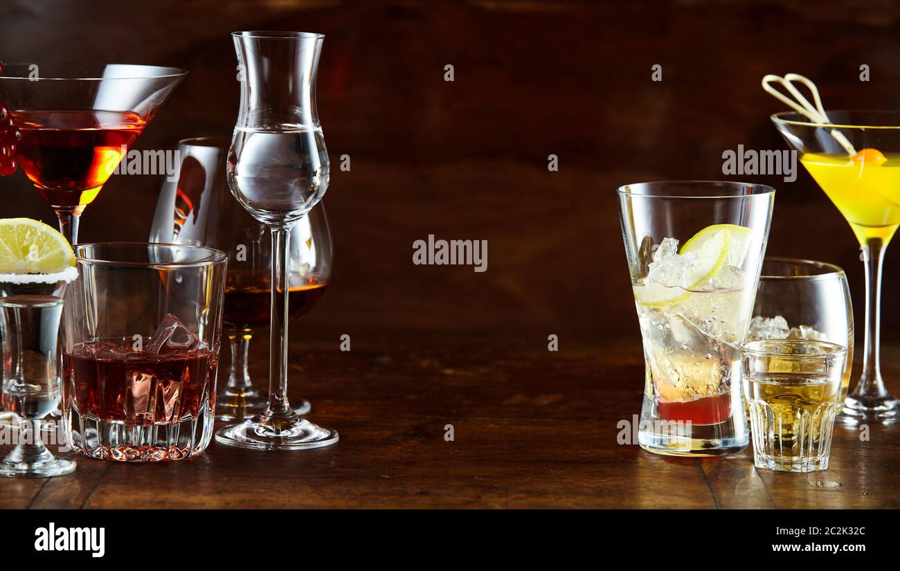 Panorama banner con una varietà di bevande alcoliche e cocktail in eleganti occhiali con centrale spazio di copia Foto Stock