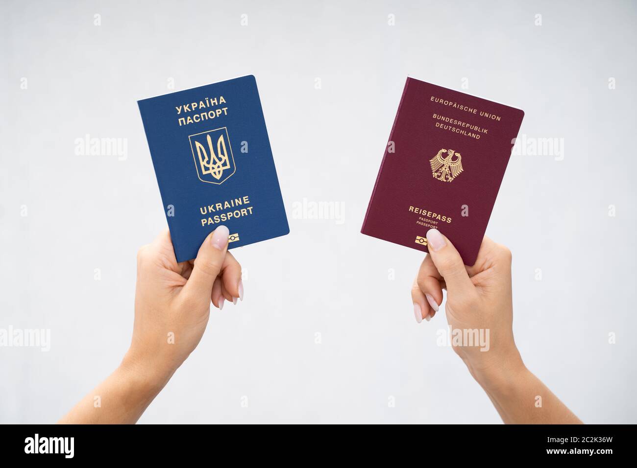 Donna che mantiene due passaporti. In Ucraina e in tedesco Foto Stock