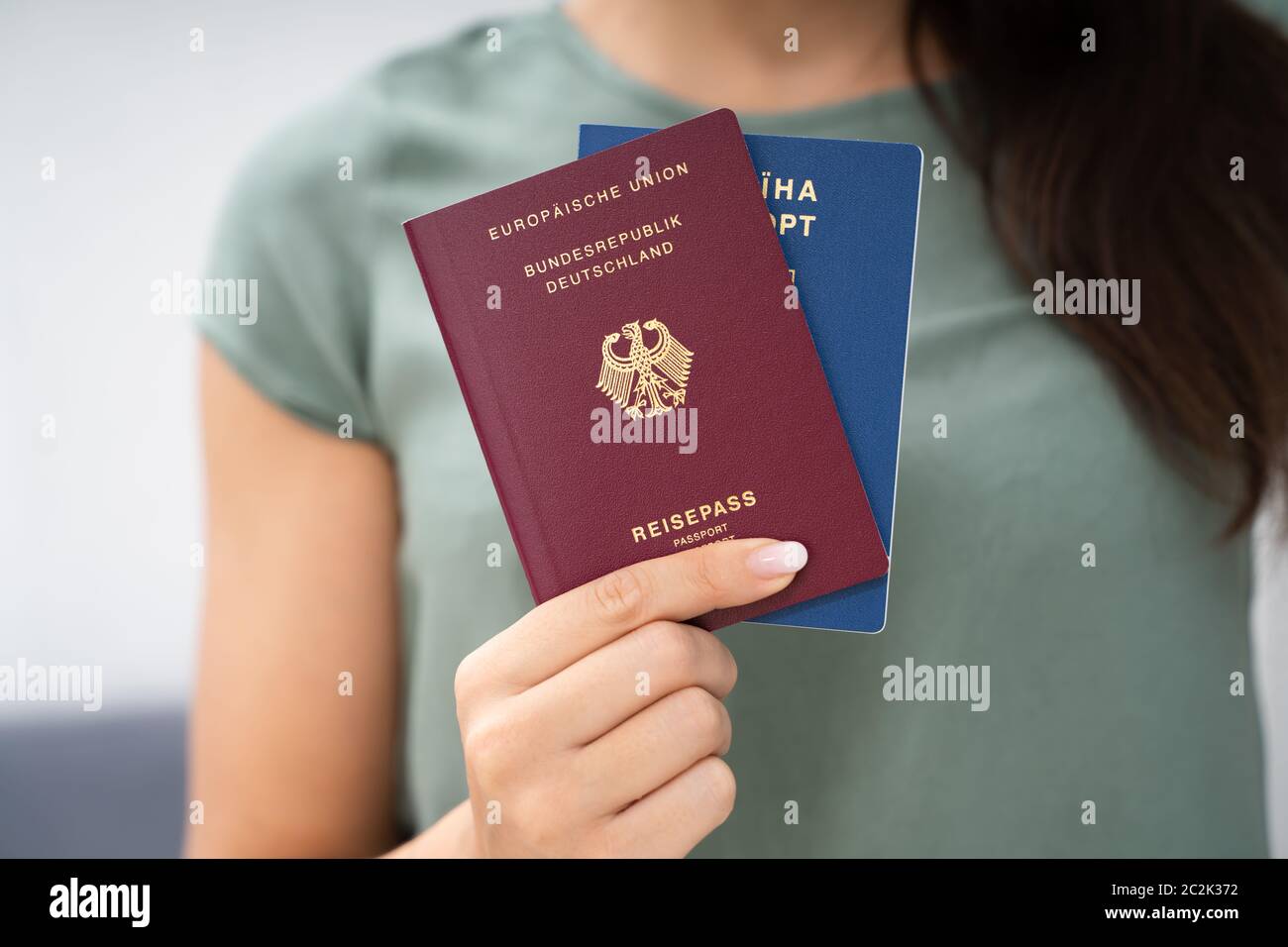 Donna che mantiene due passaporti. In Ucraina e in tedesco Foto Stock