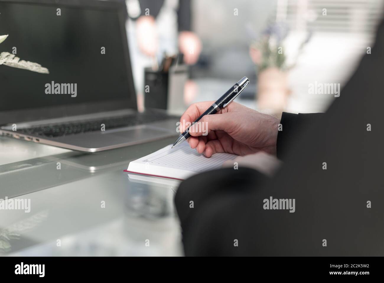 Voce maschile la scrittura a mano in notebook con penna Foto Stock