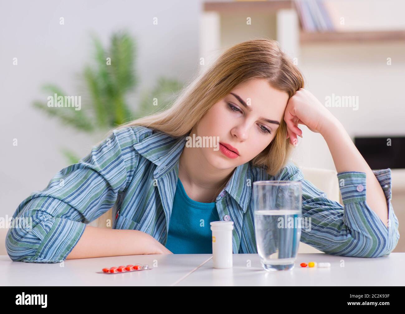 La donna di prendere le pillole per affrontare il dolore Foto Stock