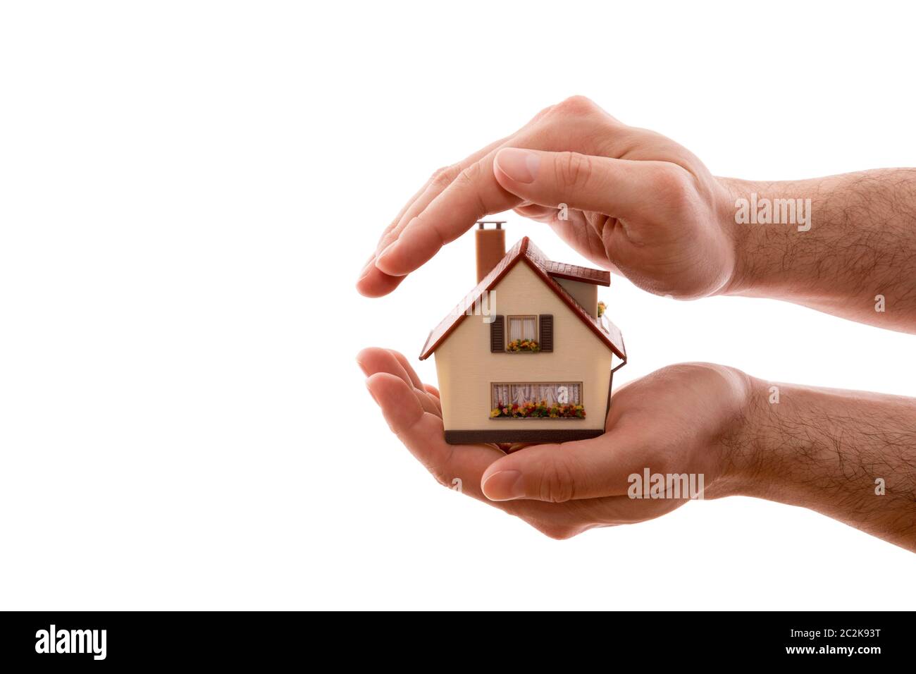 Home protezione. Piccola casa coperti da mani isolato su sfondo bianco con tracciato di ritaglio Foto Stock