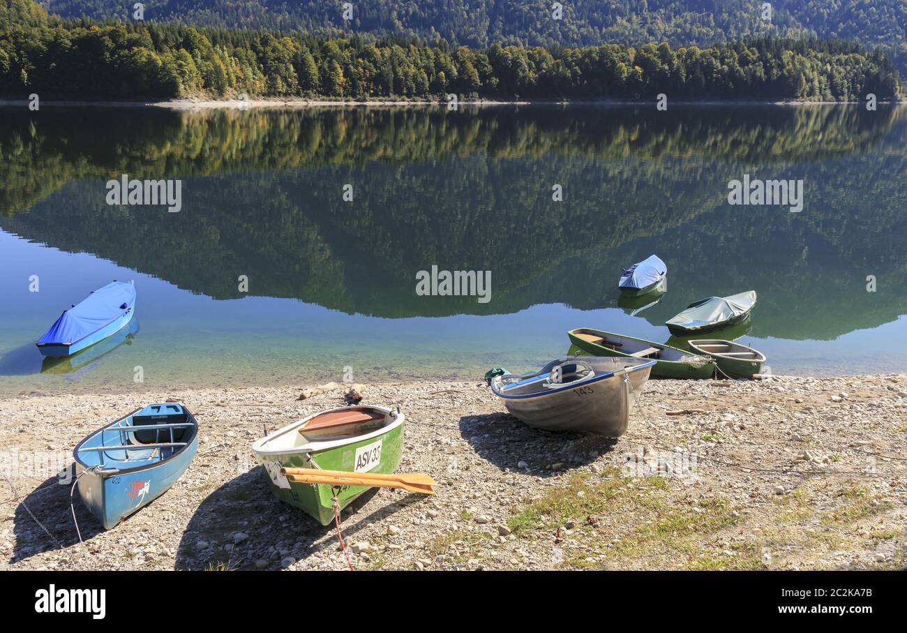Barche a remi sulla riva del bacino idrico di Sylvenstein, Baviera, Germania Foto Stock
