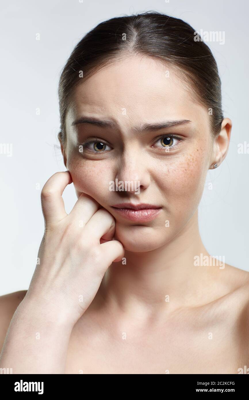 Emotiva giovane donna ritratto di viso con insoddisfazione espressione facciale. Emozioni naturali ed espressioni umane femminili concetto. Ragazza con l'oothache pai Foto Stock