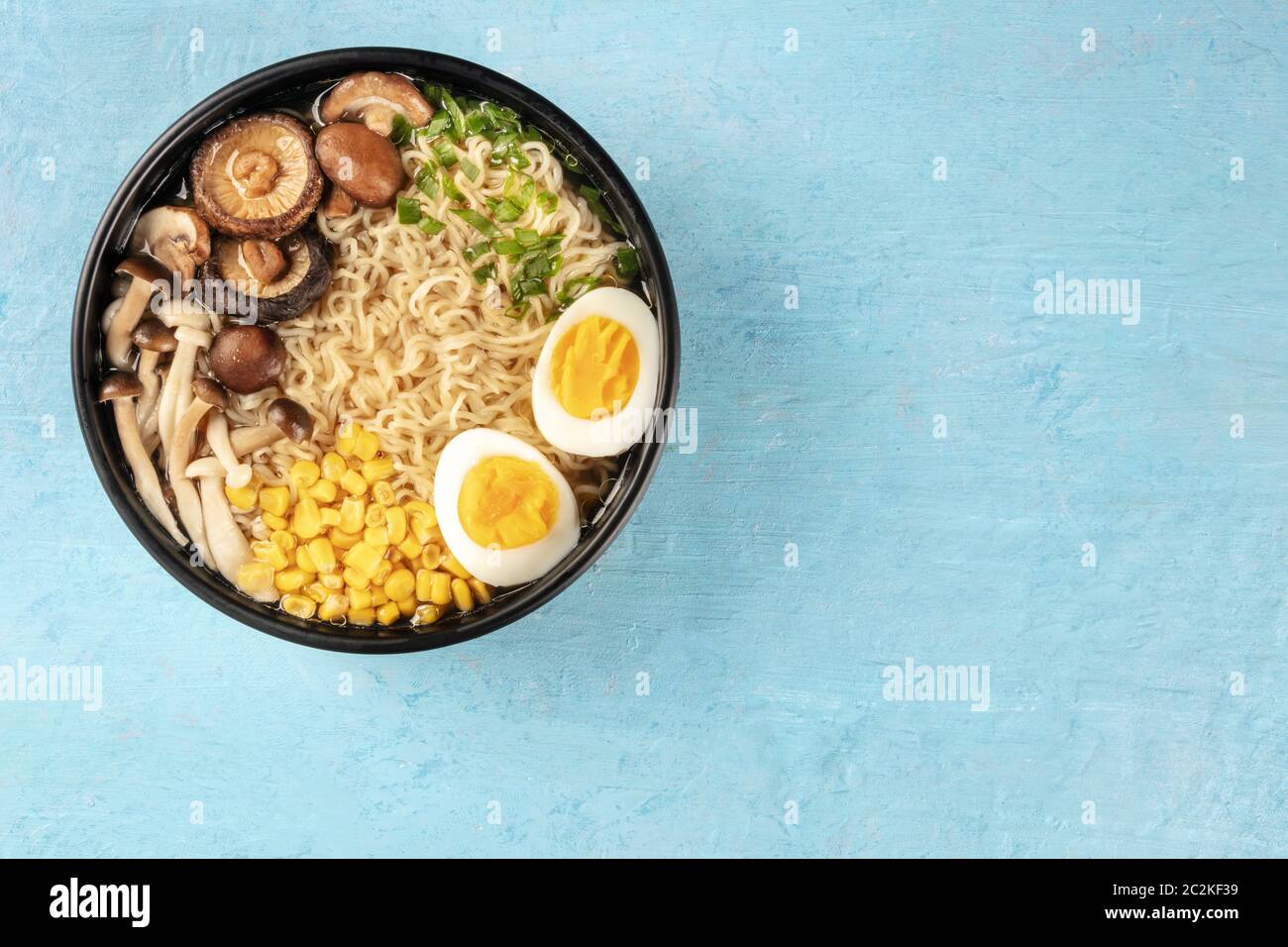 Ramen. Soba con uova, funghi e ortaggi, girato dalla parte superiore su uno sfondo blu con un posto per il testo Foto Stock