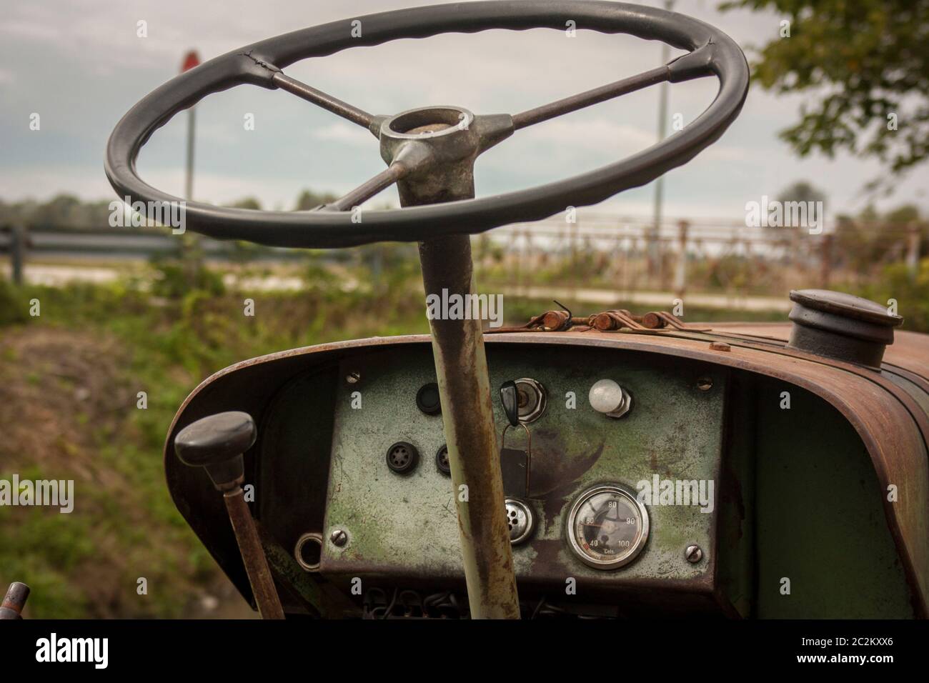 Il volante e il quadro della strumentazione (o) del cruscotto di un'annata il trattore è utilizzato come uno strumento di lavoro per coltivare i campi. Foto Stock