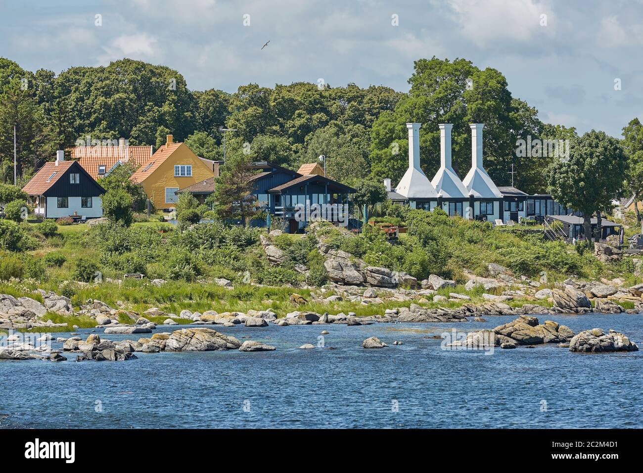 I tetti e camini di case di fumo molto piccole così tipico e famoso per il piccolo villaggio di Svaneke Foto Stock