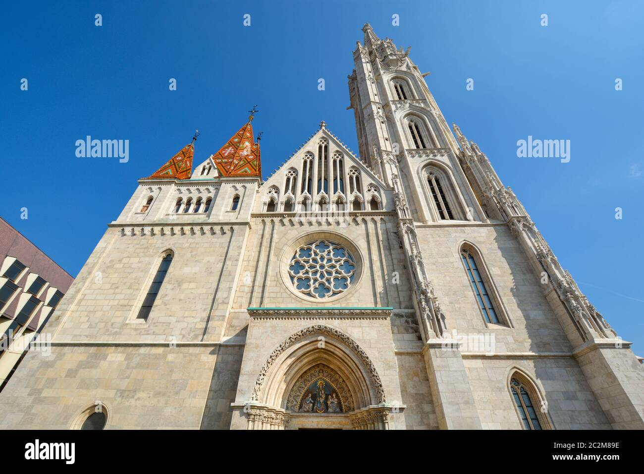 La facciata frontale e rosone della chiesa di San Mattia a Buda il complesso del Castello di Budapest in Ungheria in una giornata di sole Foto Stock