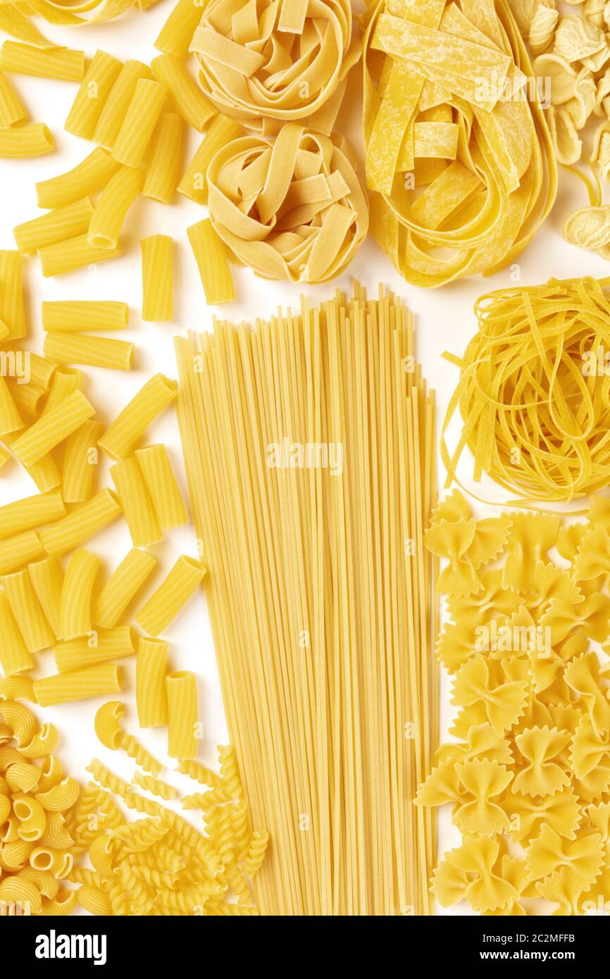 La pasta italiana Le varietà, piatto banner di laici, top shot su uno sfondo bianco. Spaghetti, maccheroni, farfalle, fusilli, pappardelle etc Foto Stock