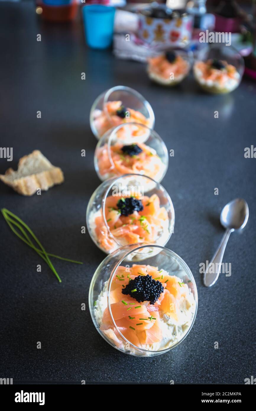 Salmone verrine ciclottero uovo formaggio fresco e letto di avocado in cucina Foto Stock