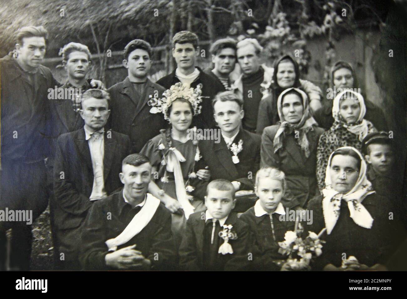 Foto d'epoca di un gruppo di persone in matrimonio. Fotografia in bianco e nero di sposi novelli con peopl Foto Stock