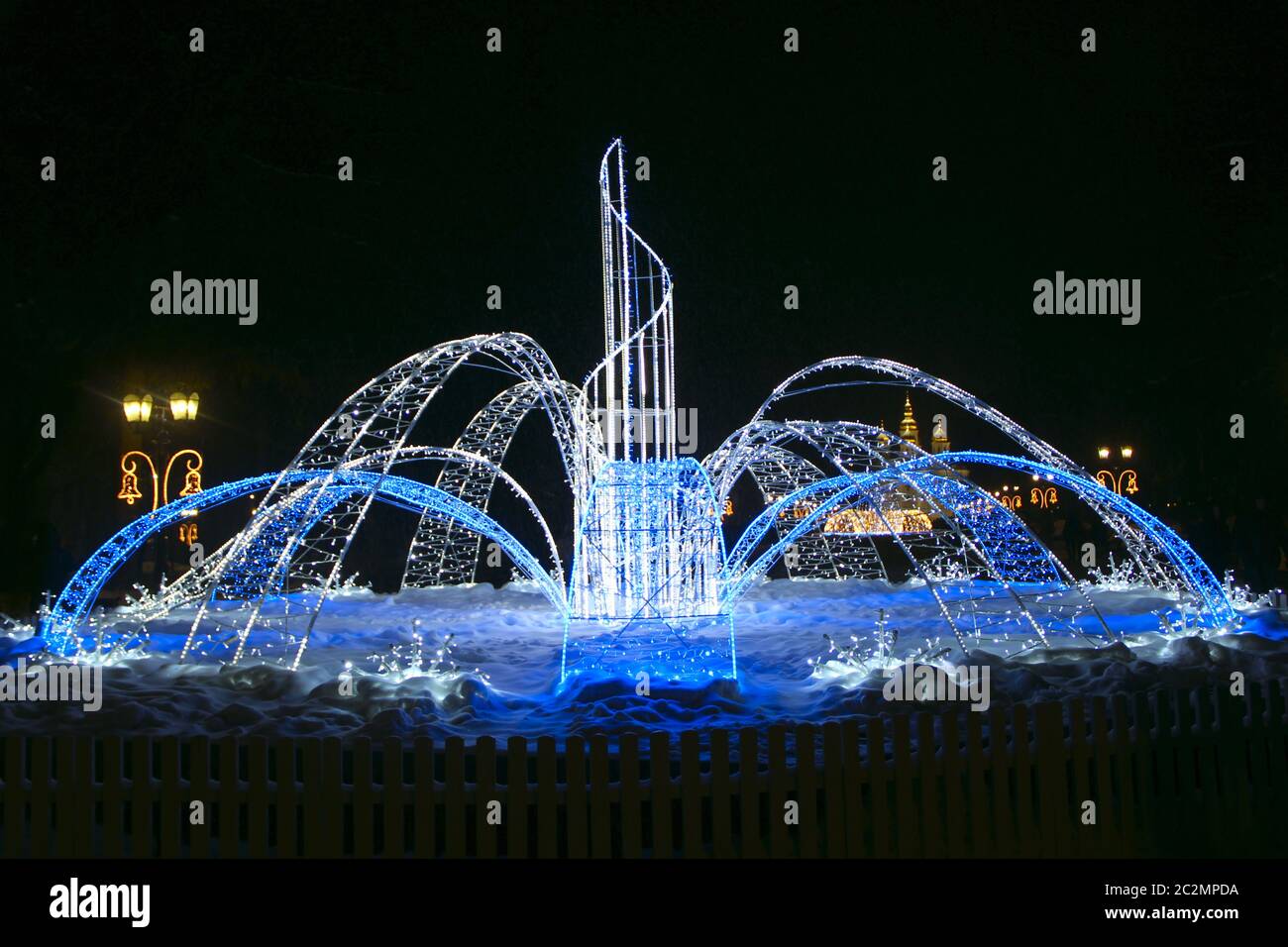 Bella fontana di colorati ghirlande vacanza scintillante e lampeggiante nel parco della città in inverno Foto Stock