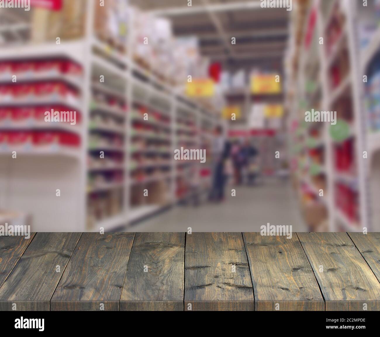 Tavole di legno d'epoca con vista sugli scaffali del supermercato. Tavolo con posto per lo shopping Foto Stock