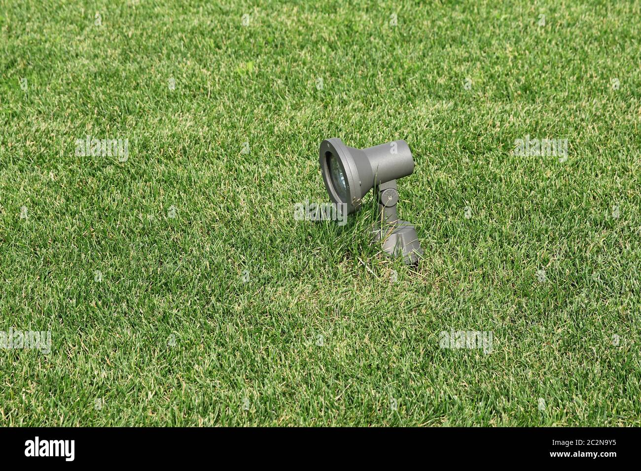 Metallo a energia solare lampada da giardino su uno sfondo di erba verde Foto Stock