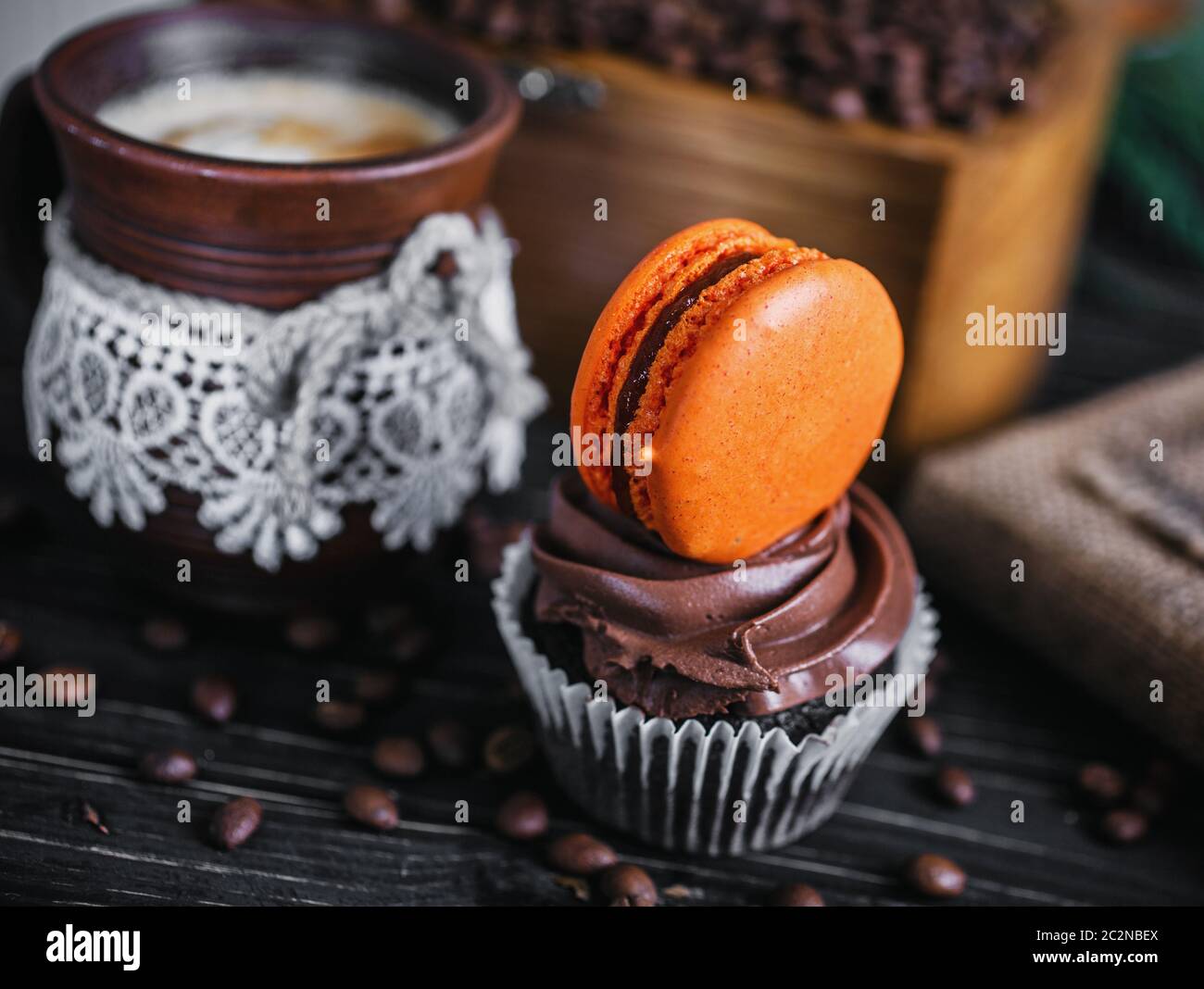 Torta al cioccolato con il dolce hamburger. La torta su un tavolo di legno accanto al caffè. Foto Stock
