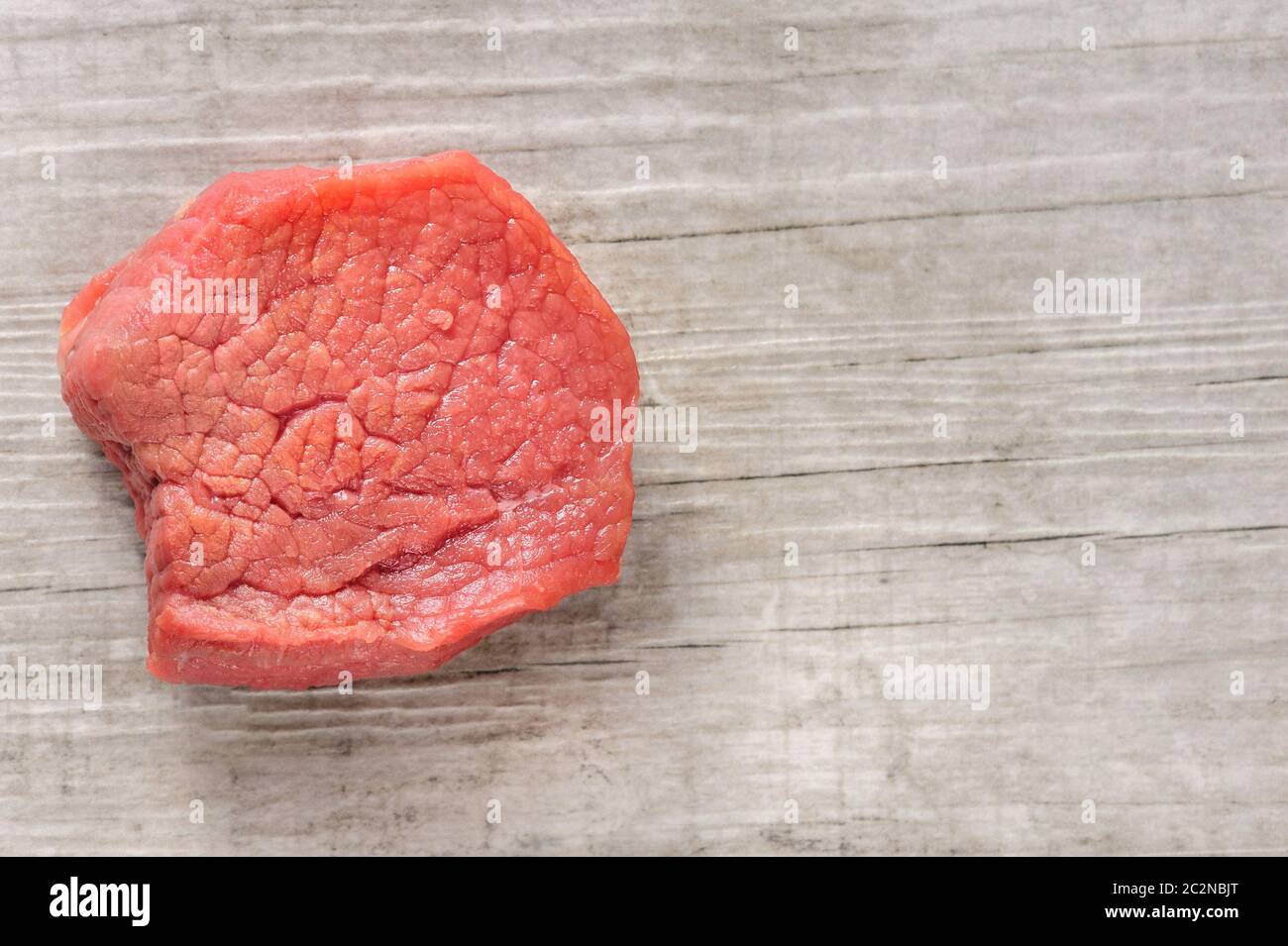 Pezzo di carne di manzo crudo di carne in legno bianco o sfondo di pietra Foto Stock