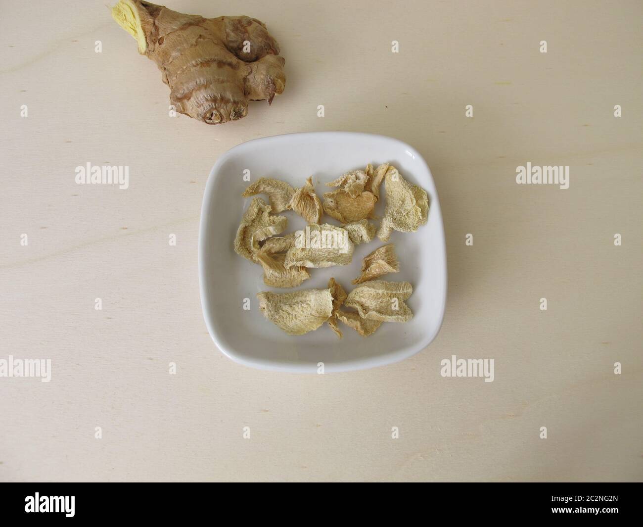 Zenzero essiccato su una tavola di legno Foto Stock