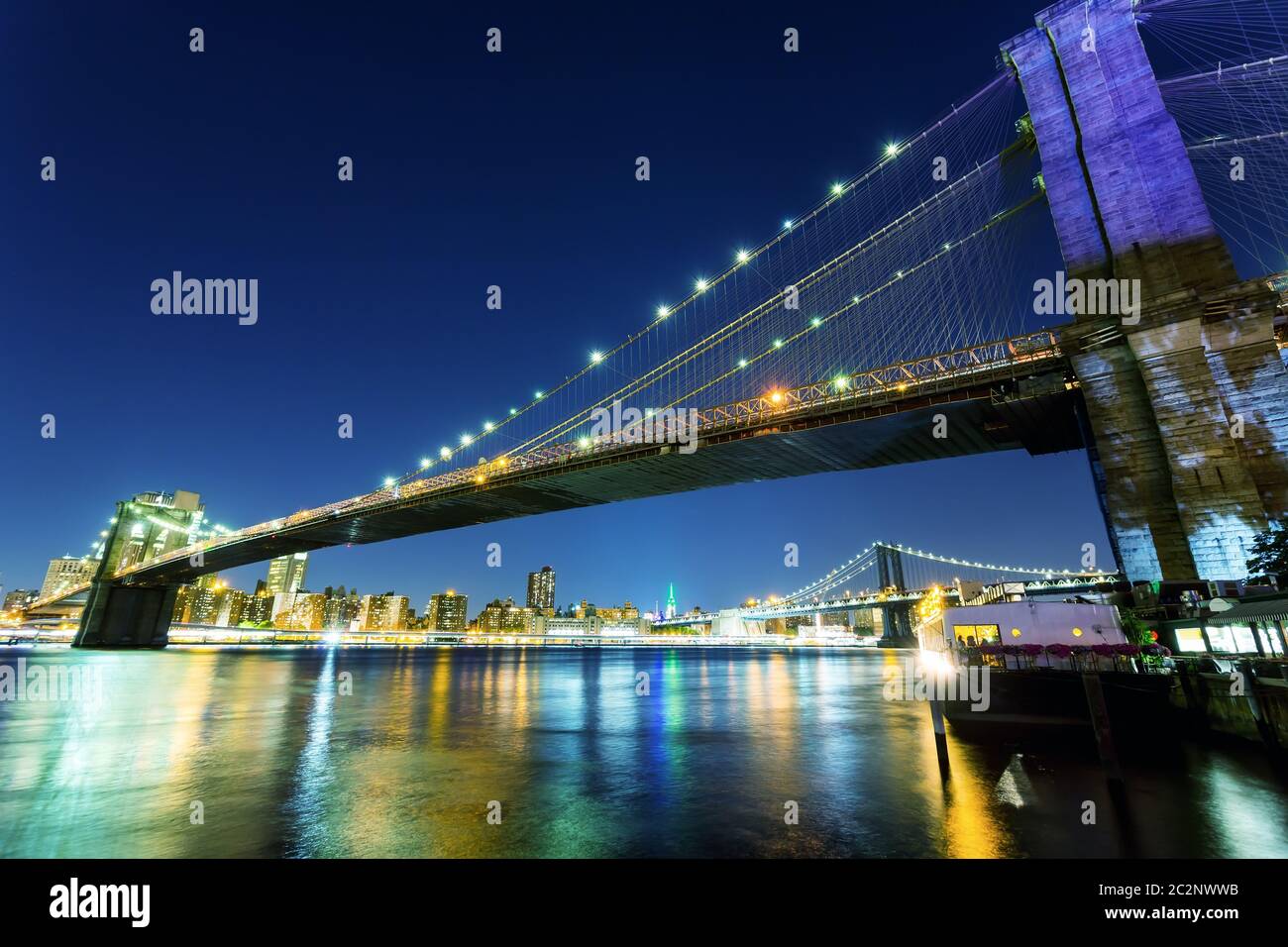 Ponte illuminato di Brooklyn e vista di manhattan dal fiume hudson di notte, New York City USA Foto Stock