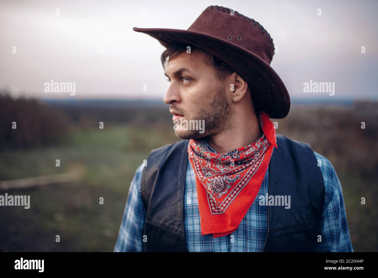 Ritratto di brutale cowboy in giacca di pelle e cappello, occidentale. Vintage persona maschile, retrò moda americana nel selvaggio west style Foto Stock