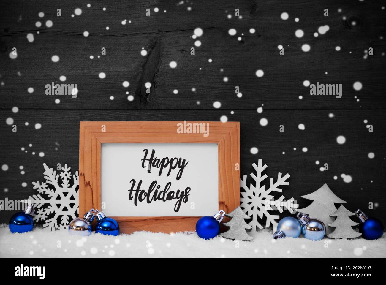 La calligrafia Inglese Buone Vacanze. Blue ornamento di Natale come albero, il simbolo del fiocco di neve e la sfera. Sfondo di legno con la neve e i fiocchi di neve Foto Stock