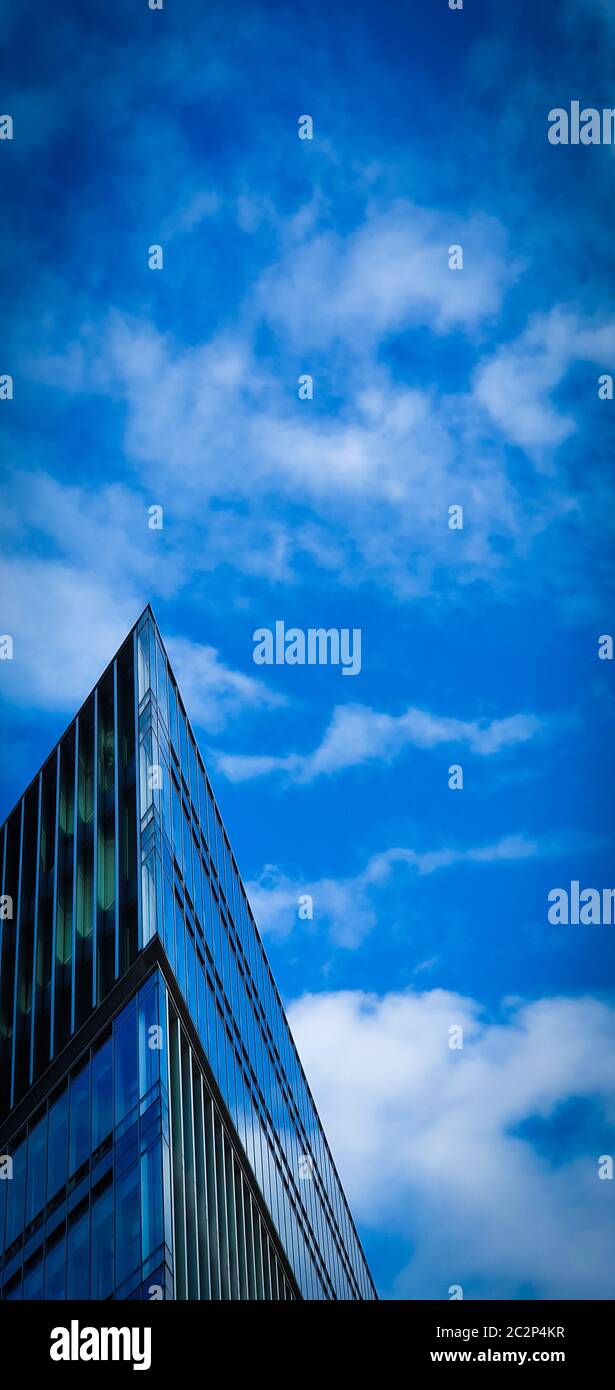 Architettura moderna. Estetica minimale. Basso angolo di visione di un futuristico edificio triangolare contro un cielo blu chiaro dello sfondo. Edificio ad angolo. Foto Stock Architettura moderna. Estetica minimale. Basso angolo di visione di un futuristico edificio triangolare contro un cielo blu chiaro dello sfondo. Edificio ad angolo. Foto Stock