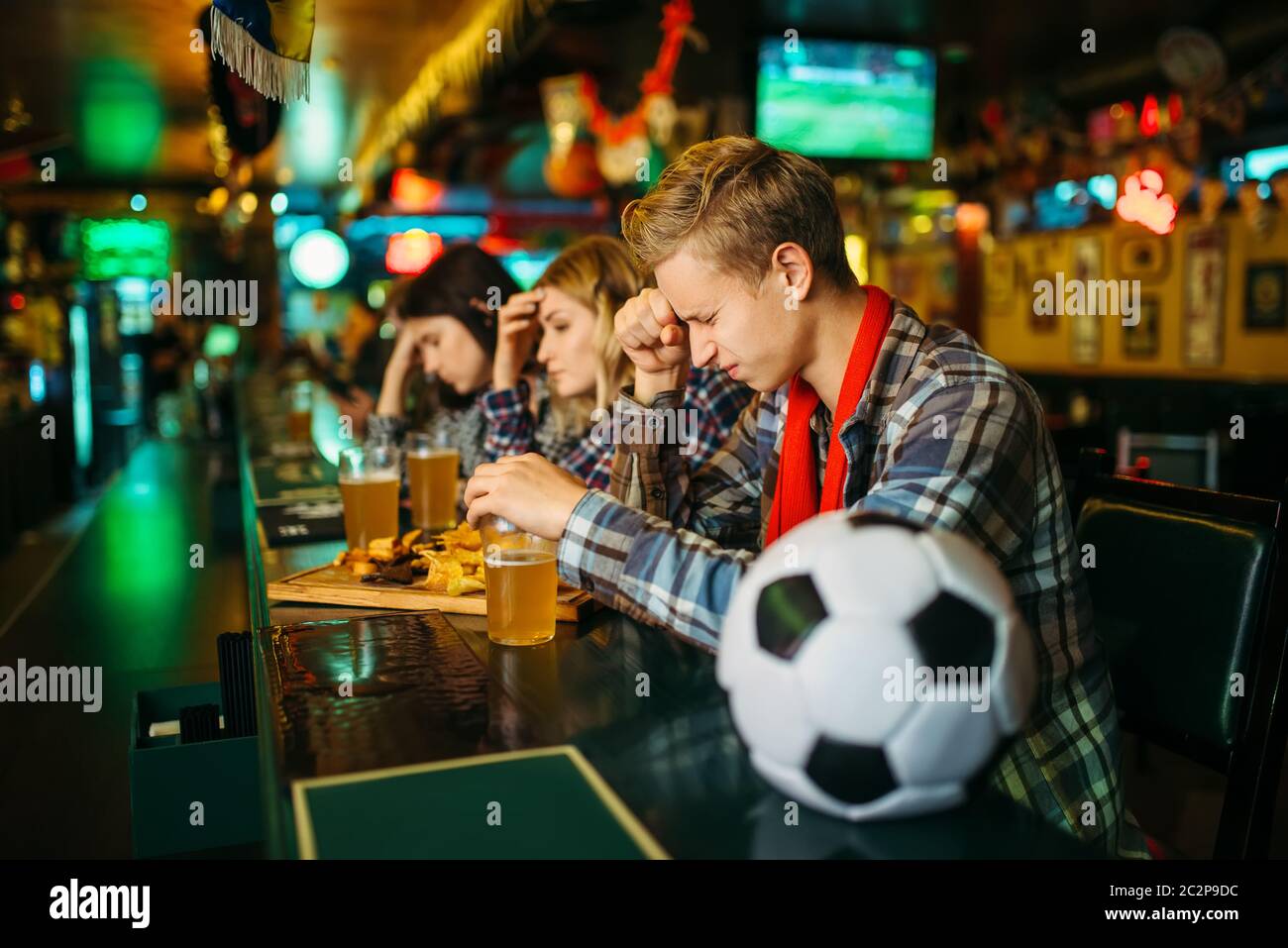 Triste tifoso copre il viso con le mani al contatore in sports bar. La diffusione di programmi televisivi, squadra preferita la perdita Foto Stock