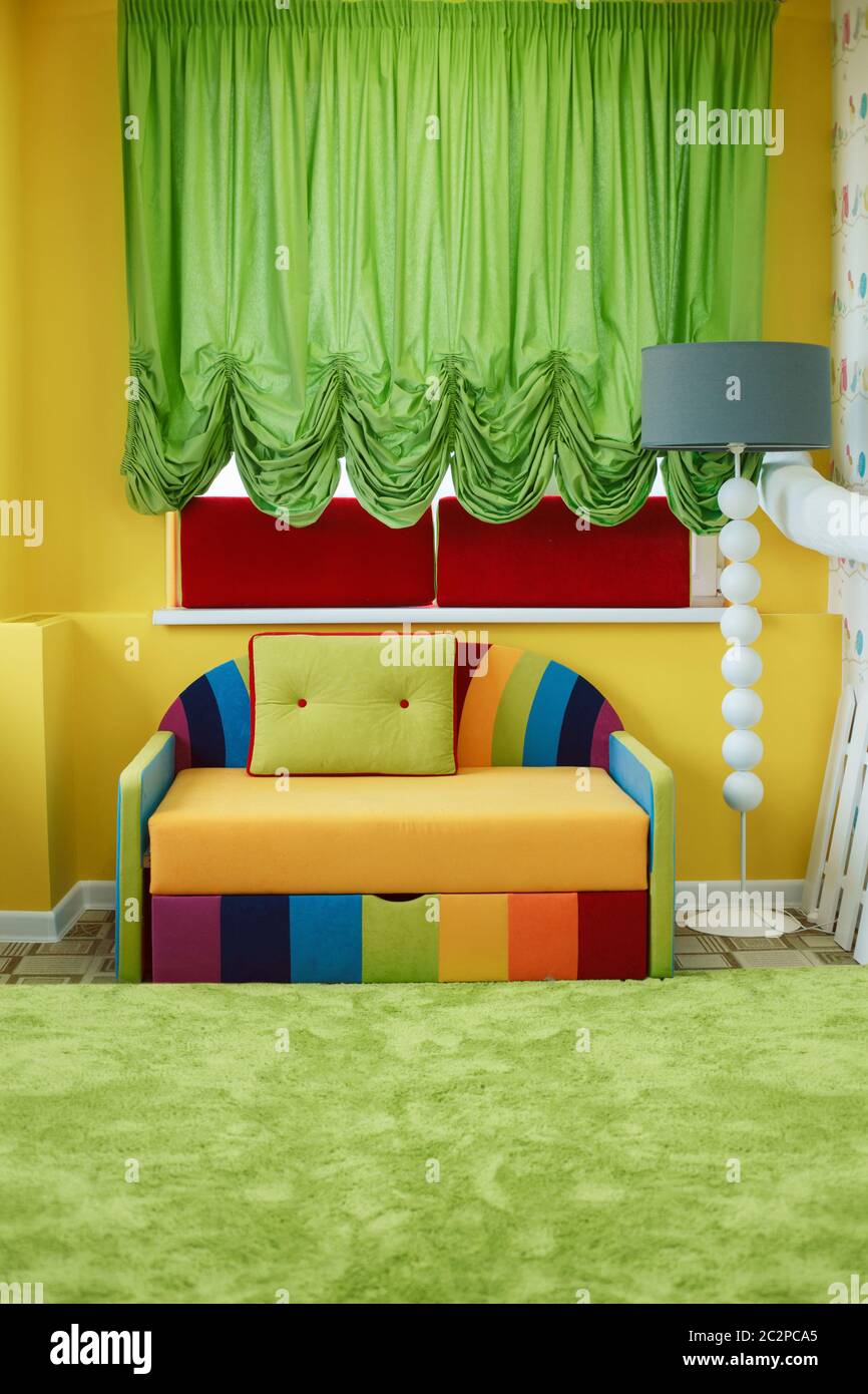 Camera per bambini decorata con un divano colorato. Concetto di sala giochi per prescolare. Foto Stock