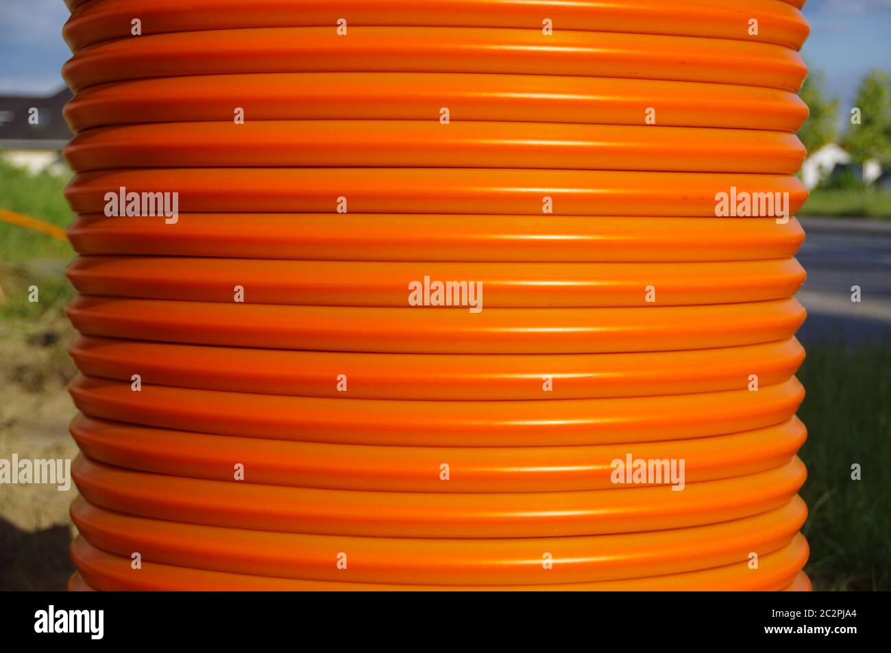 Un rotolo di cavi arancioni. Costruzione di impianti in fibra ottica. Foto Stock