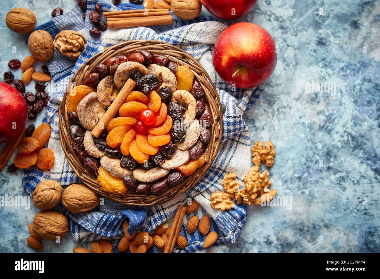 Composizione di frutta secca e noci in piccolo vaso in vimini collocato sul tavolo di pietra Foto Stock