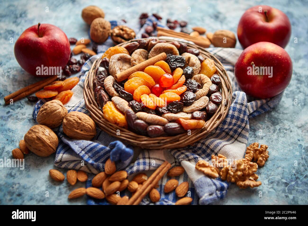 Composizione di frutta secca e noci in piccolo vaso in vimini collocato sul tavolo di pietra Foto Stock