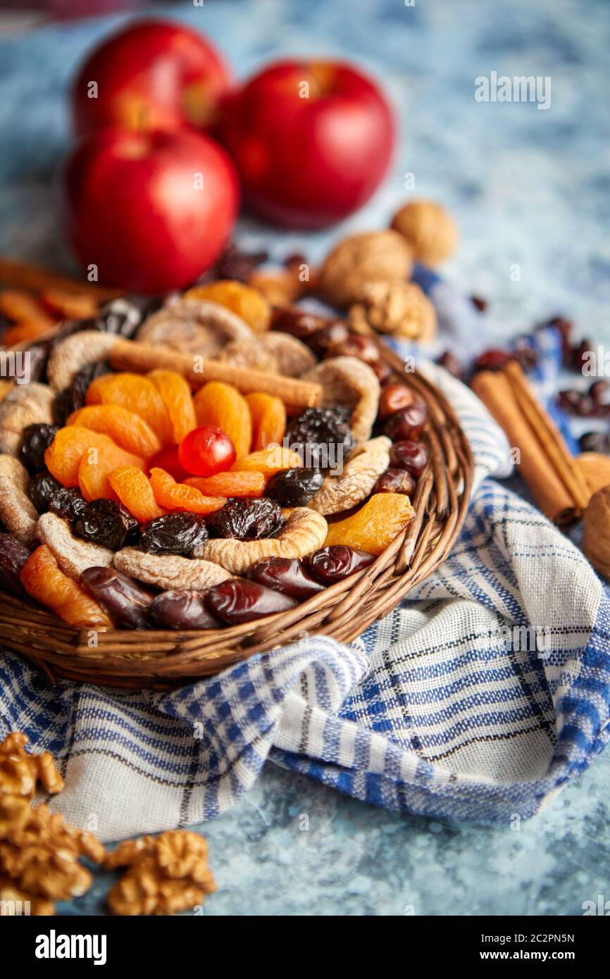 Composizione di frutta secca e noci in piccolo vaso in vimini collocato sul tavolo di pietra Foto Stock