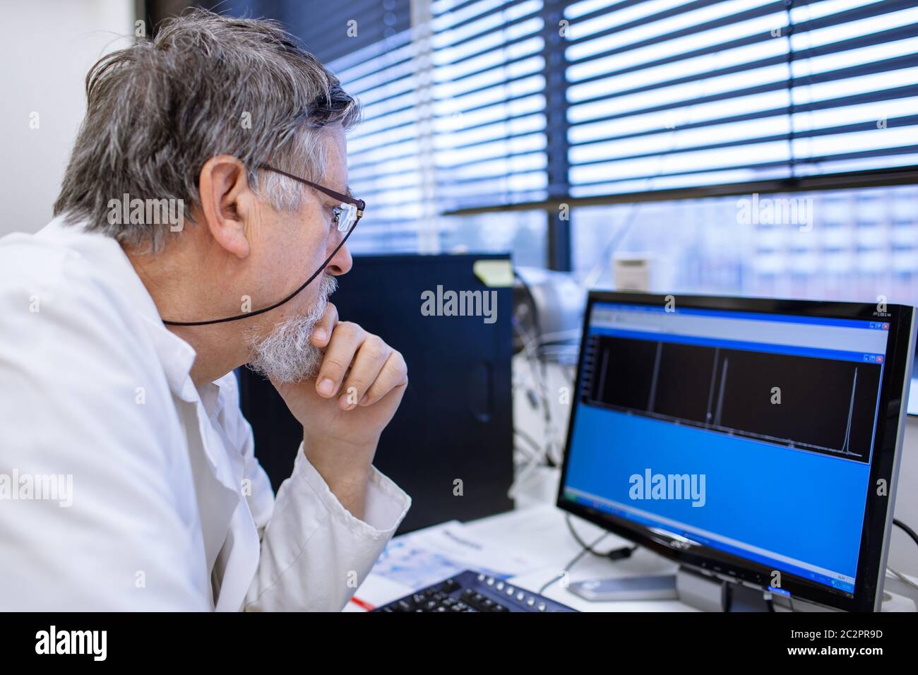 Maschio senior researcher di effettuare attività di ricerca scientifica in un laboratorio (SHALLOW DOF; dai toni di colore immagine) Foto Stock