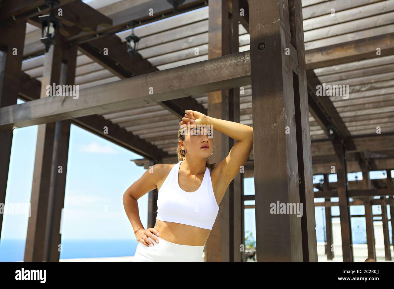 Bella donna che fa esercizi di stretching in spiaggia Foto Stock