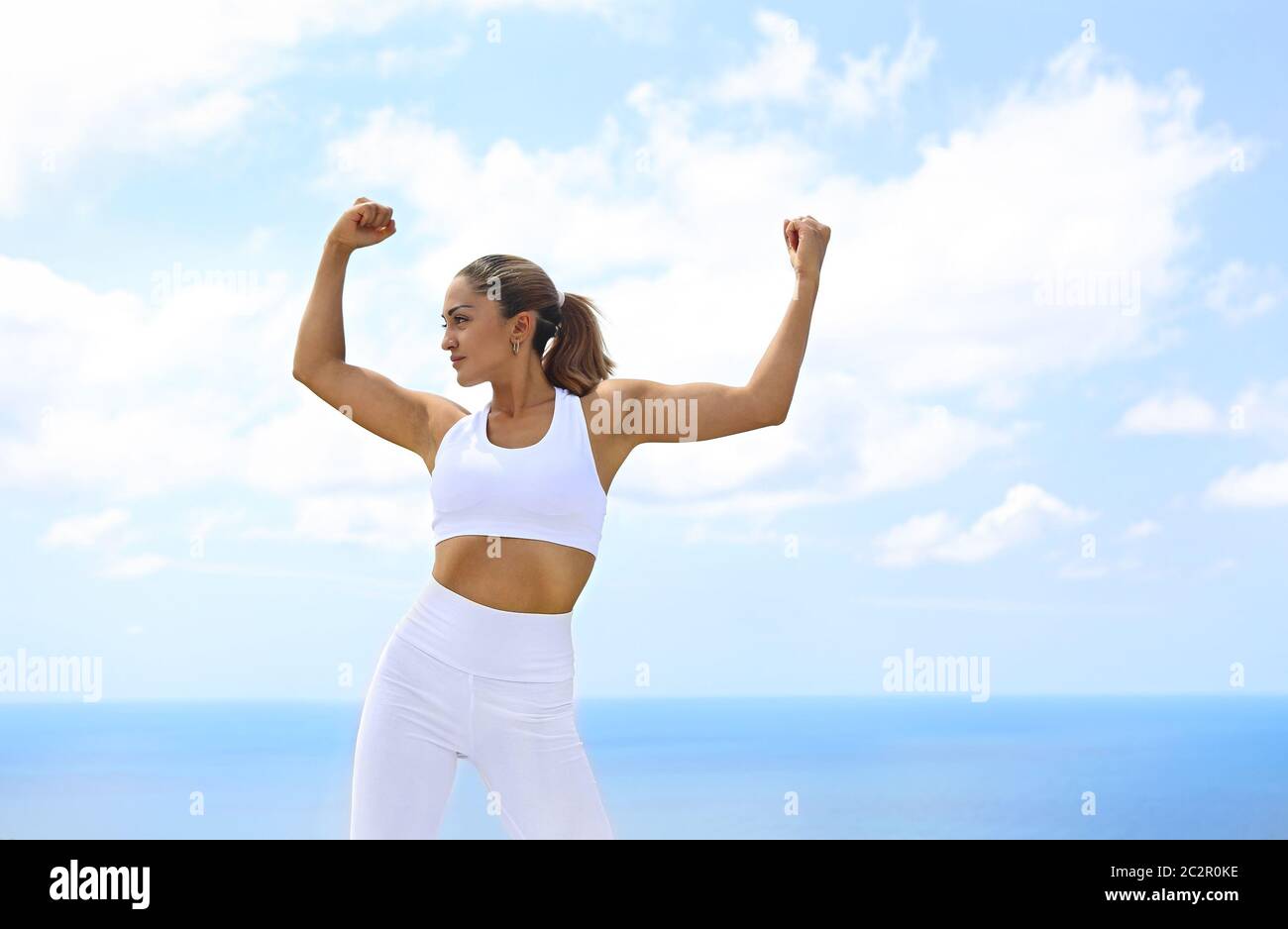 Bella donna che fa esercizi di stretching in spiaggia Foto Stock