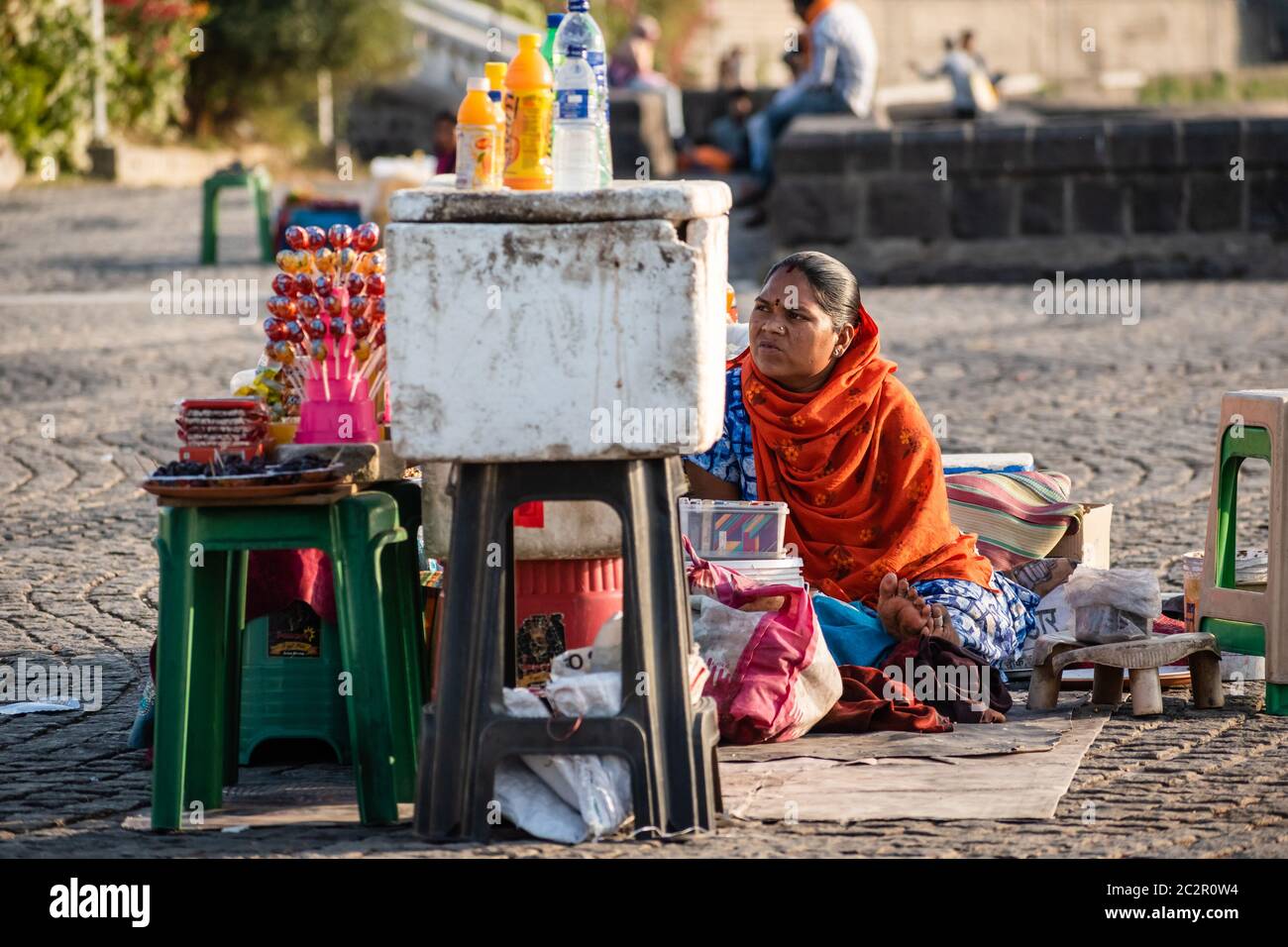 Nagpur, Maharahstra, India - Marzo 2019: Un ritratto candido di una donna indiana che vende bevande e spuntini per strada. Foto Stock