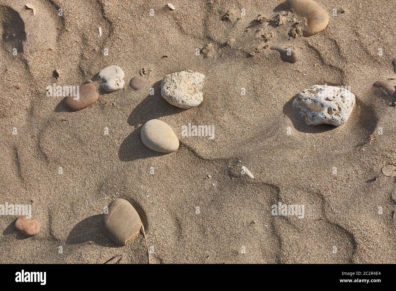 Consistenza di sabbia livellata dal vento con alcuni ciottoli Foto Stock