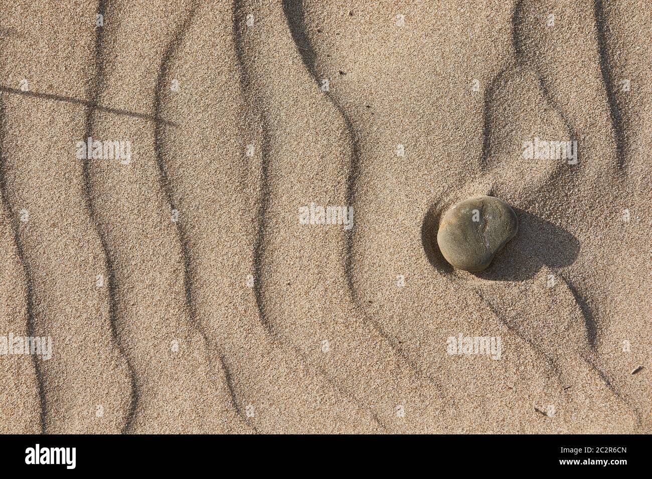 Consistenza di sabbia livellata dal vento con alcuni ciottoli Foto Stock