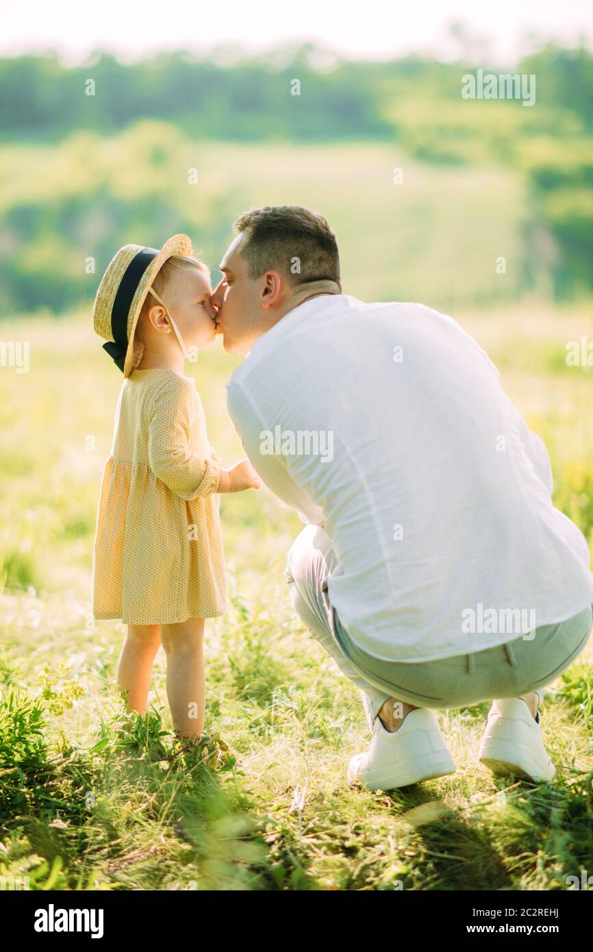 Un padre bacia la figlia durante una passeggiata nel parco. Foto Stock