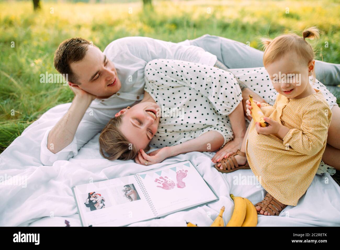 Famiglia con bambina riposa durante il picnic nel parco. Foto Stock
